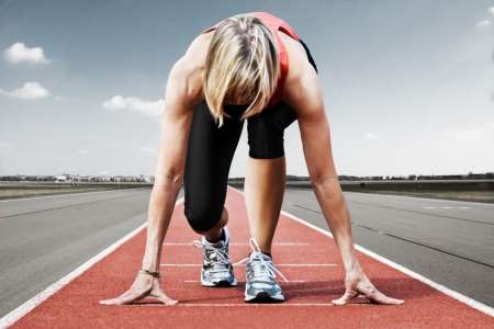 Woman in the start position on race track