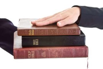 Hand on a stack of Bibles