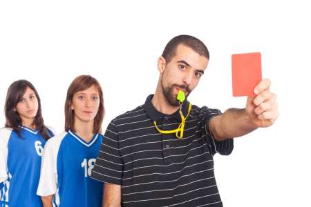 Soccer referee holding red card to enforce rules