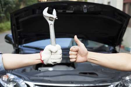 hand of mechanic with thumbs up and tool