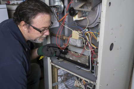 Service technician working on furnace