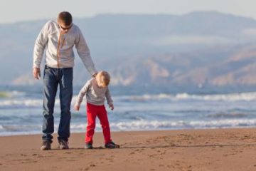 Father and son walkin on California beach