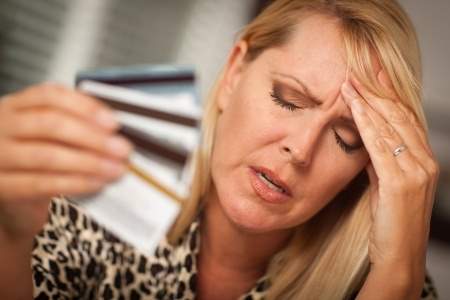 Worried woman holding credit cards