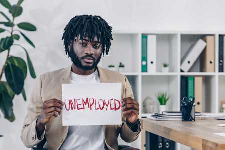 Young man holding unemployed sign