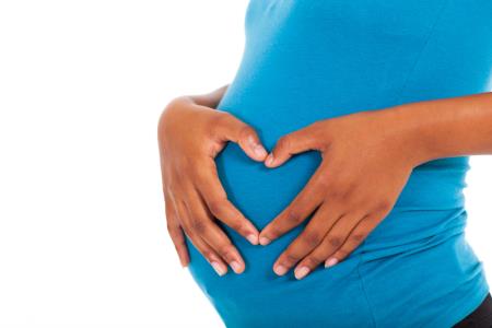 pregnant african american woman hands on belly forming a heart shape