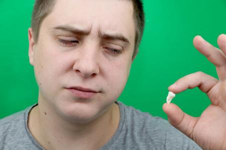 Man holding extracted wisdom tooth